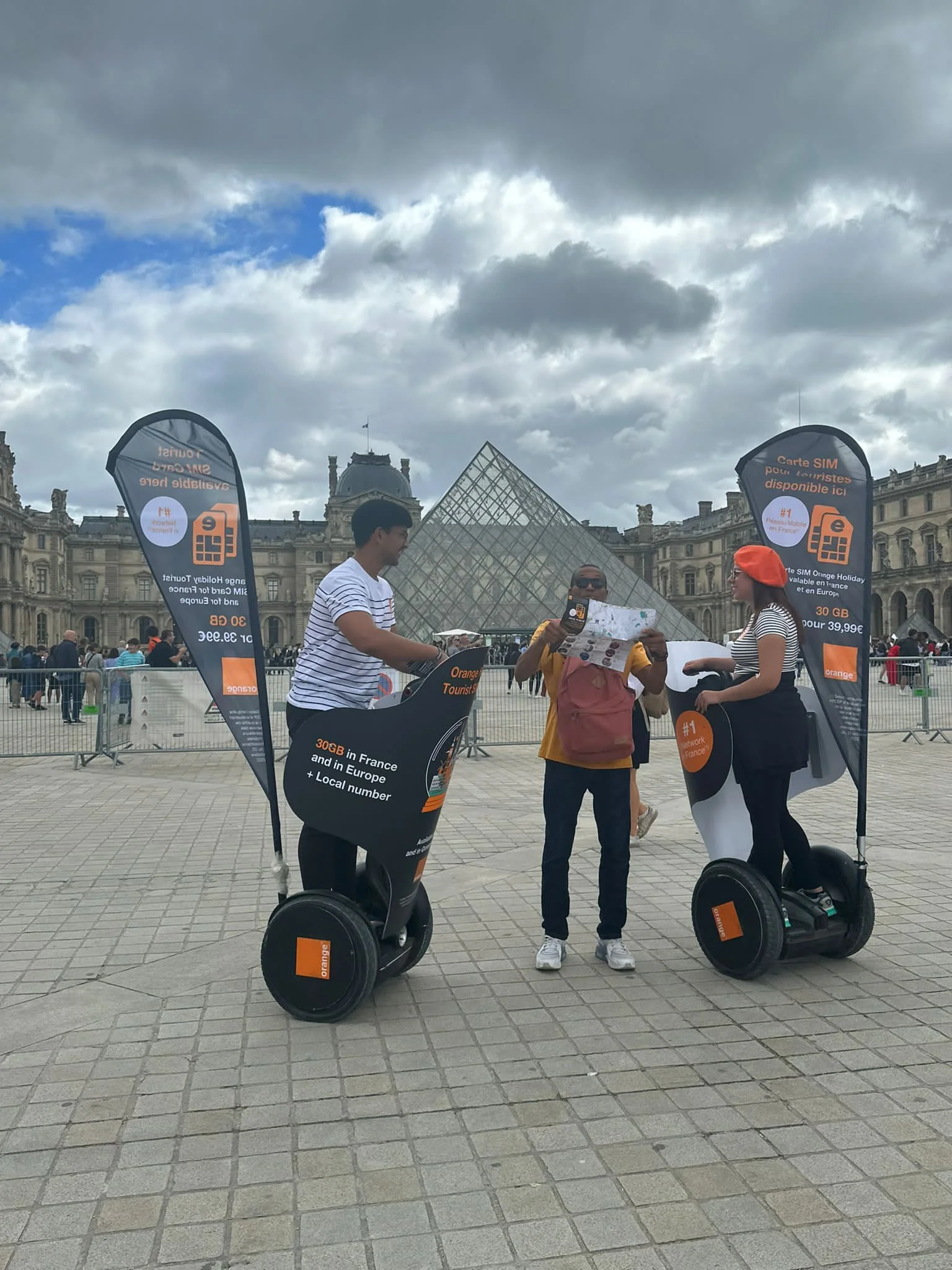 Photo of two promoters in Paris using Segways in front of the Louvre pyramid during a street marketing campaign